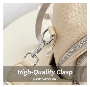 Gros plan sur le crochet en métal argenté et le détail de la sangle en cuir beige