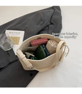 Top view of spacious interior of cream bucket bag with umbrella, wallet and smartphones