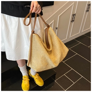 Détail du grand sac cabas en paille tissée avec bandoulière en cuir marron