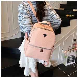 Détail sac à dos en cuir grainé rose avec logo triangulaire métal et fermeture éclair