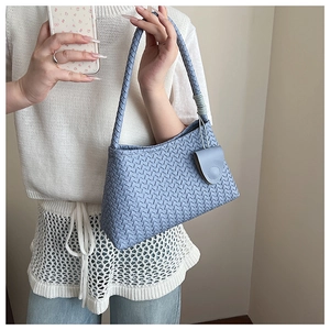Detail of light blue woven leather tote bag with checkerboard pattern and matching strap