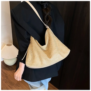 Détail du sac hobo tissé beige montrant le motif en maille ajourée et la bandoulière