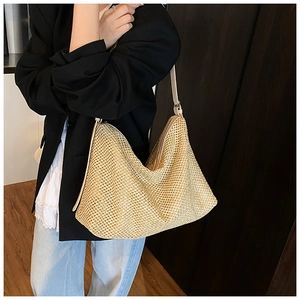 Gros plan sur la texture de ce sac cabas tressé et sa bandoulière en paille