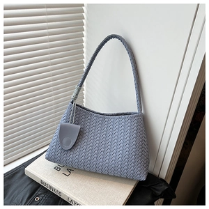 Macro view showing the intricate woven texture and circular charm on the fog blue hobo bag