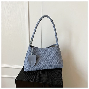 Detail view of woven light blue leather hobo bag with textured finish and braided handle
