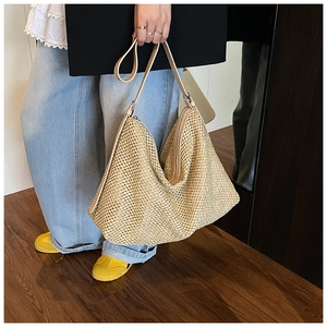 Détail du sac hobo en paille tressée montrant la texture naturelle et la bandoulière