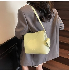 Detail of avocado green bucket bag with lychee texture and small coin purse attachment