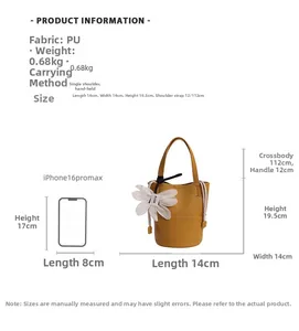 Detailed size view of mustard yellow bucket bag with iPhone 16 Pro Max comparison