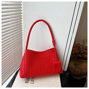 Detailed close-up of a red woven faux leather shoulder bag featuring intricate textures