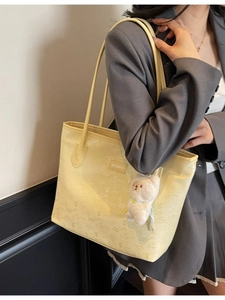 Large yellow faux leather tote bag with embossed pattern and cute plush bear charm