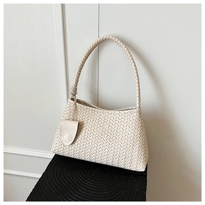 Detail of hand-woven beige shoulder bag featuring intricate 3D rhombus textures