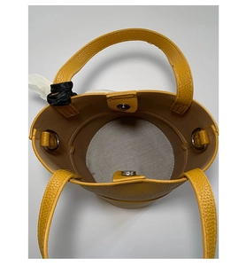 Top view of yellow lychee leather bucket bag with magnetic snap and gray lining