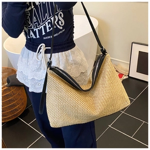 Détail du sac cabas en paille tissée avec bandoulières en cuir noir pour les vacances
