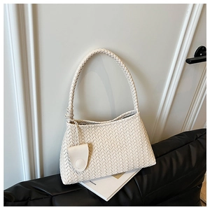 Close-up of beige woven leather shoulder bag showing intricate cross-knit texture