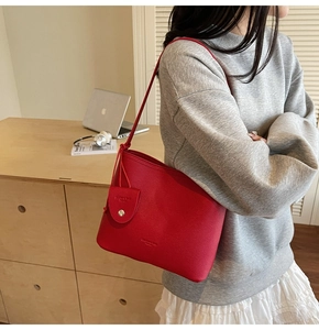 Detail of red lychee textured bucket bag with matching mini coin purse and shoulder strap
