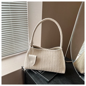 Detailed close-up of beige woven hobo bag with matching side pouch and round handle