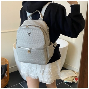 Vue détaillée du sac à dos en cuir gris texturé avec logo en métal et multiples poches