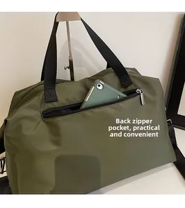Detail view of the back zipper pocket on a large army green travel duffel bag