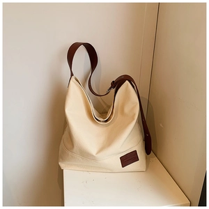 Detail of canvas Hobo bag showing cream fabric texture and brown leather strap