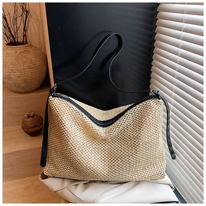 Détails du tissage fin et des lanières en cuir noir de ce grand sac cabas en paille