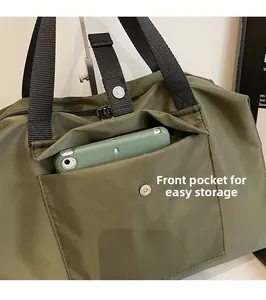Army green nylon travel bag detail showing front pocket with magnetic snap for phone storage