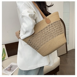 Detail of hollow mesh straw tote bag featuring brown leather shoulder straps