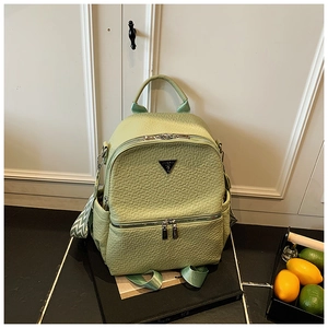 Détail d'un sac à dos en cuir vert menthe avec logo triangulaire et sangles ondulées