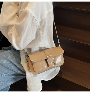 Detail of light khaki crossbody bag with gloss finish and decorative front pockets
