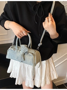 Light blue denim cylinder pillow bag with rivet bow and adjustable straps for women