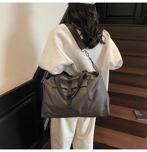 Detail of grey waterproof travel bag with double handles and adjustable shoulder strap