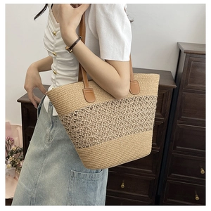 Detailed view of handmade woven straw tote with leather handles and hollow mesh pattern