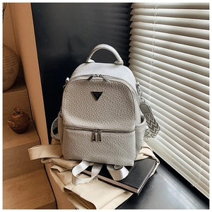 Détail du sac à dos en similicuir gris gaufré avec sangle tissée et logo métal