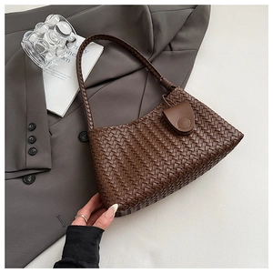 Close-up of intricate dark brown woven texture and craftsmanship on an underarm bag