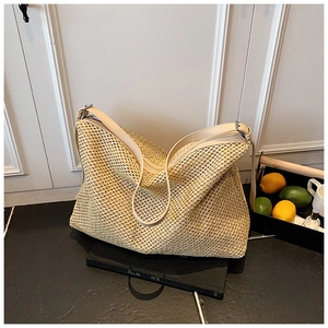 Gros plan détaillé montrant la texture tissée serrée de ce sac cabas en paille beige