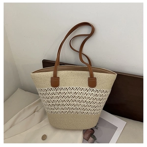 Detailed view of handmade woven straw tote with leather handles and crochet stitching