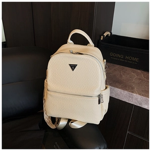 Détail du sac à dos en similicuir texturé crème avec des sangles à motifs géométriques