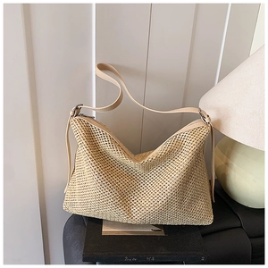 Détail du sac fourre-tout en paille tissée à mailles ajourées avec bandoulière en similicuir