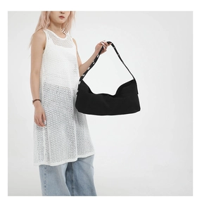 Detail of black large capacity shoulder bag with unique metallic eyelet strap design