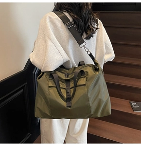 Olive green travel bag detail with detachable strap and waterproof nylon texture