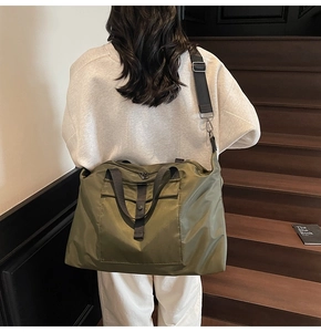 Detail of army green nylon travel bag with high-density fabric and wide shoulder strap