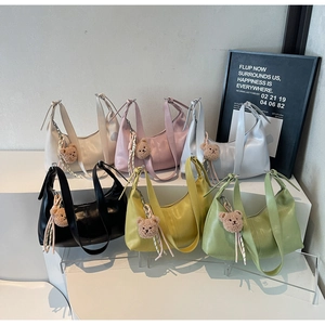 Chic dumpling-style half-moon shoulder bags featuring colorful designs and cute bear charms