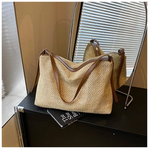 Détail du sac cabas en paille tissée avec anses en cuir marron et fermeture éclair