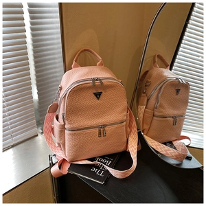 Détail d'un sac à dos rose à texture litchi avec bandoulière tissée géométrique