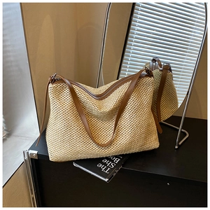 Vue détaillée du sac cabas en paille tissée avec anses en cuir marron et fermeture éclair