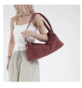 Detailed view of wine red canvas hobo bag featuring wide straps and silver rivet accents