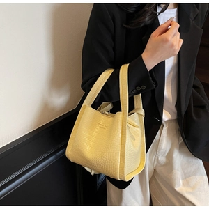 Detail of yellow crocodile pattern tote bag featuring Fashion print and textured faux leather