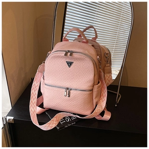Détail d'un sac à dos rose en cuir grainé avec large bandoulière et finitions argentées