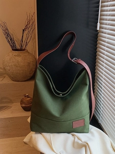 Large dark green canvas tote bag with brown leather strap and minimalist vintage style