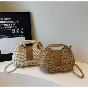 Close-up of woven straw crossbody bags in beige and tan with elegant gold metal locks