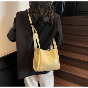 Detailed view of yellow faux leather tote with crocodile pattern and dual shoulder straps